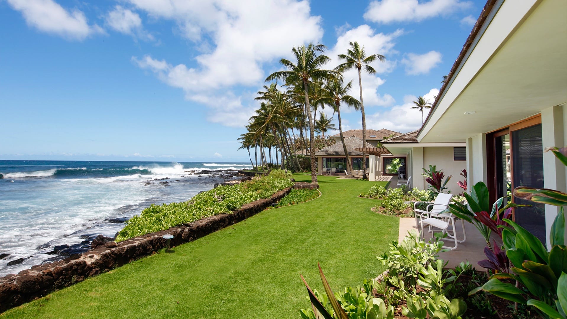 Oceanfront house with palm trees.