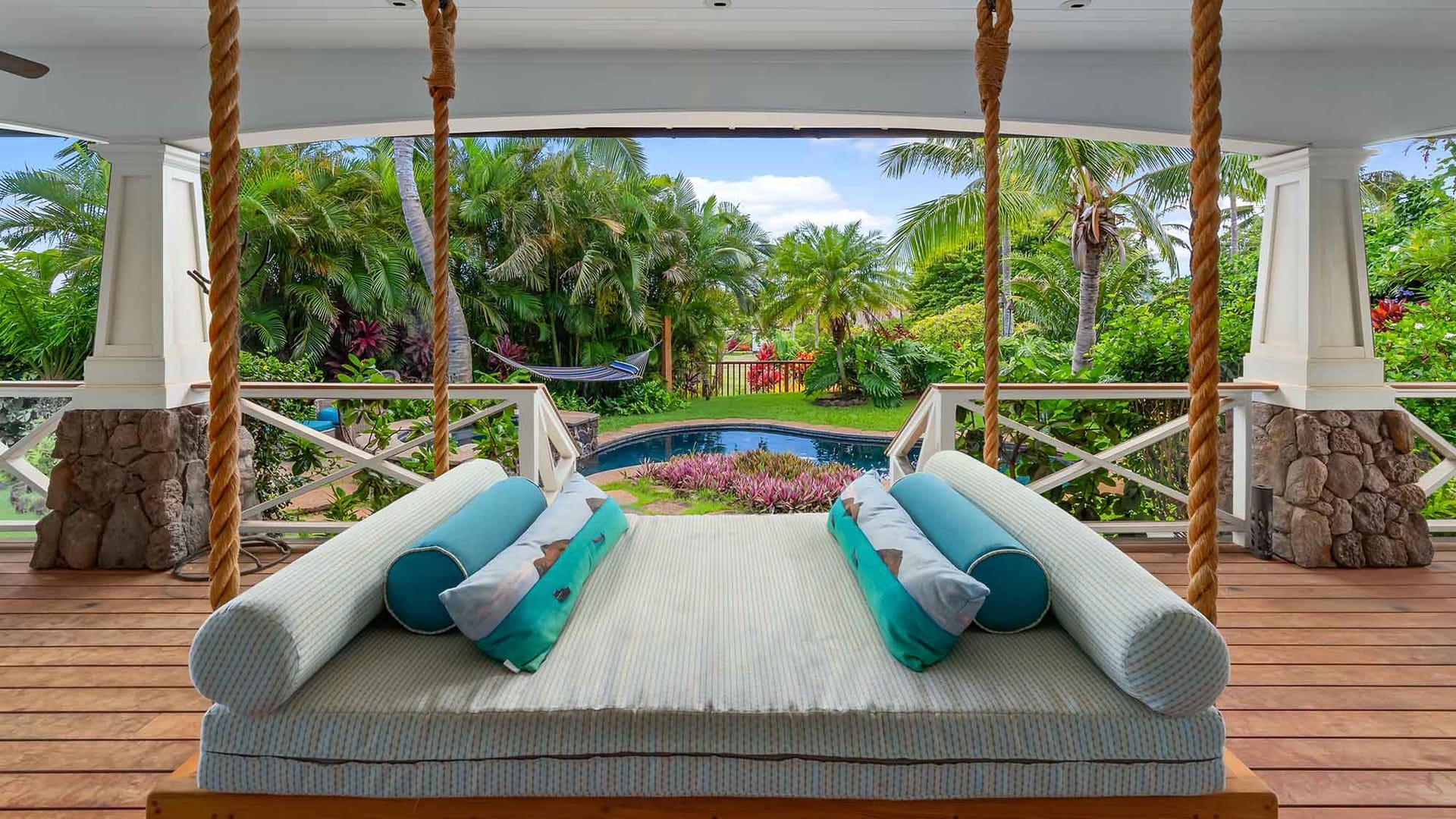 Outdoor swing bed overlooking garden.