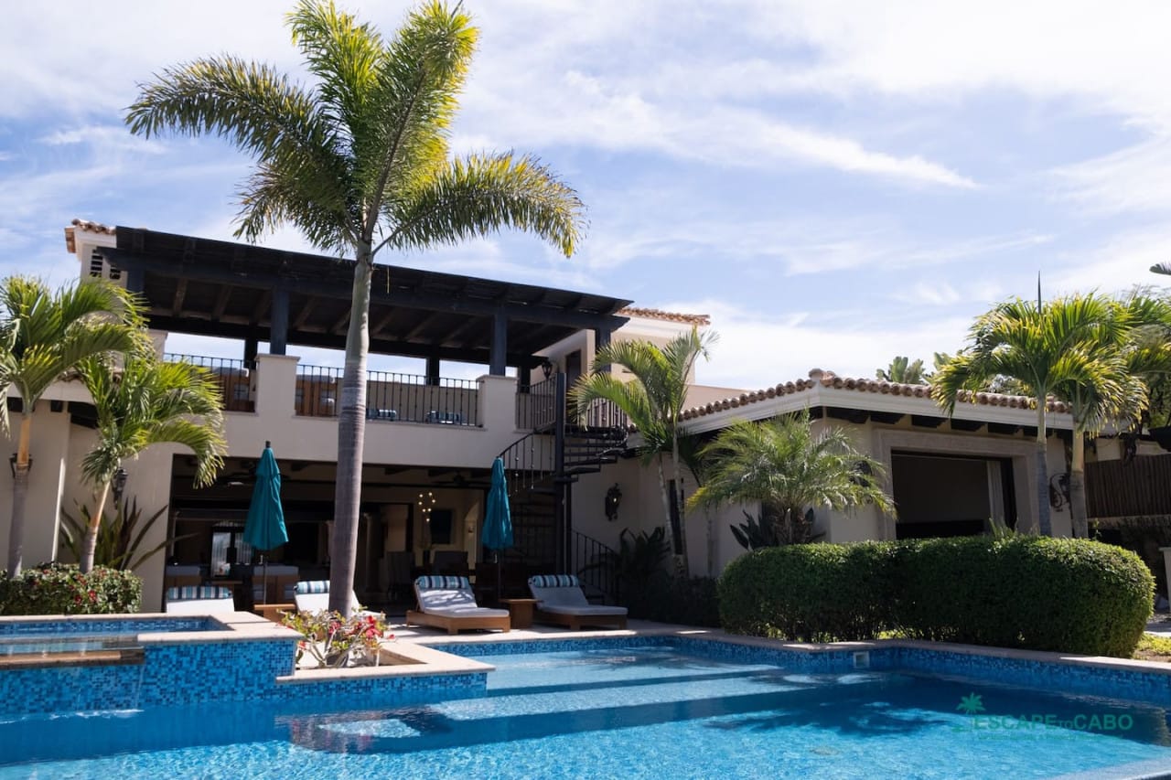 Luxurious villa with pool, palm trees.