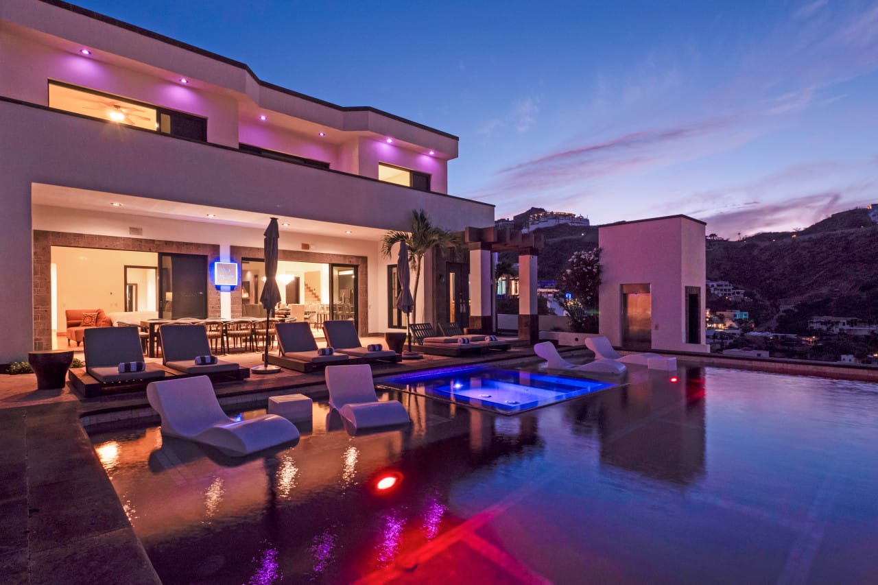 Modern house with illuminated pool.