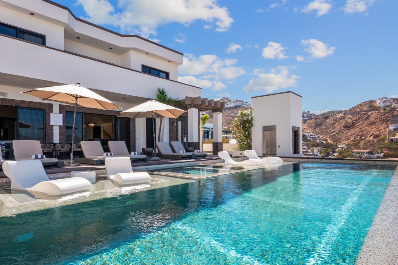 Luxury villa with poolside loungers.