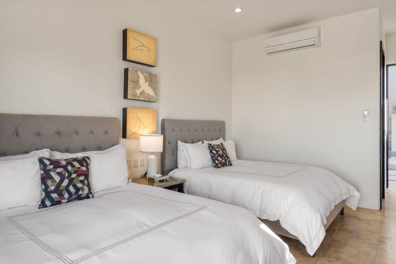 Two beds in modern bedroom.