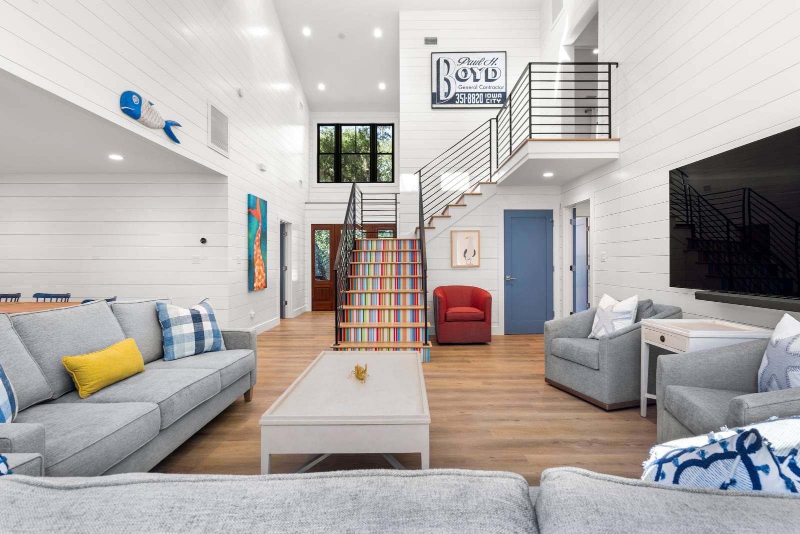 Spacious living room with colorful staircase.