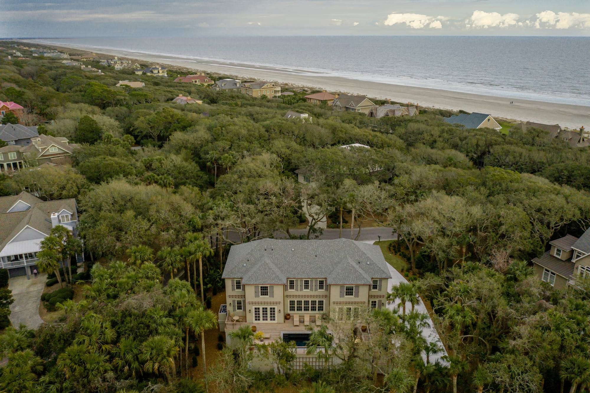 Beachfront house surrounded by trees.