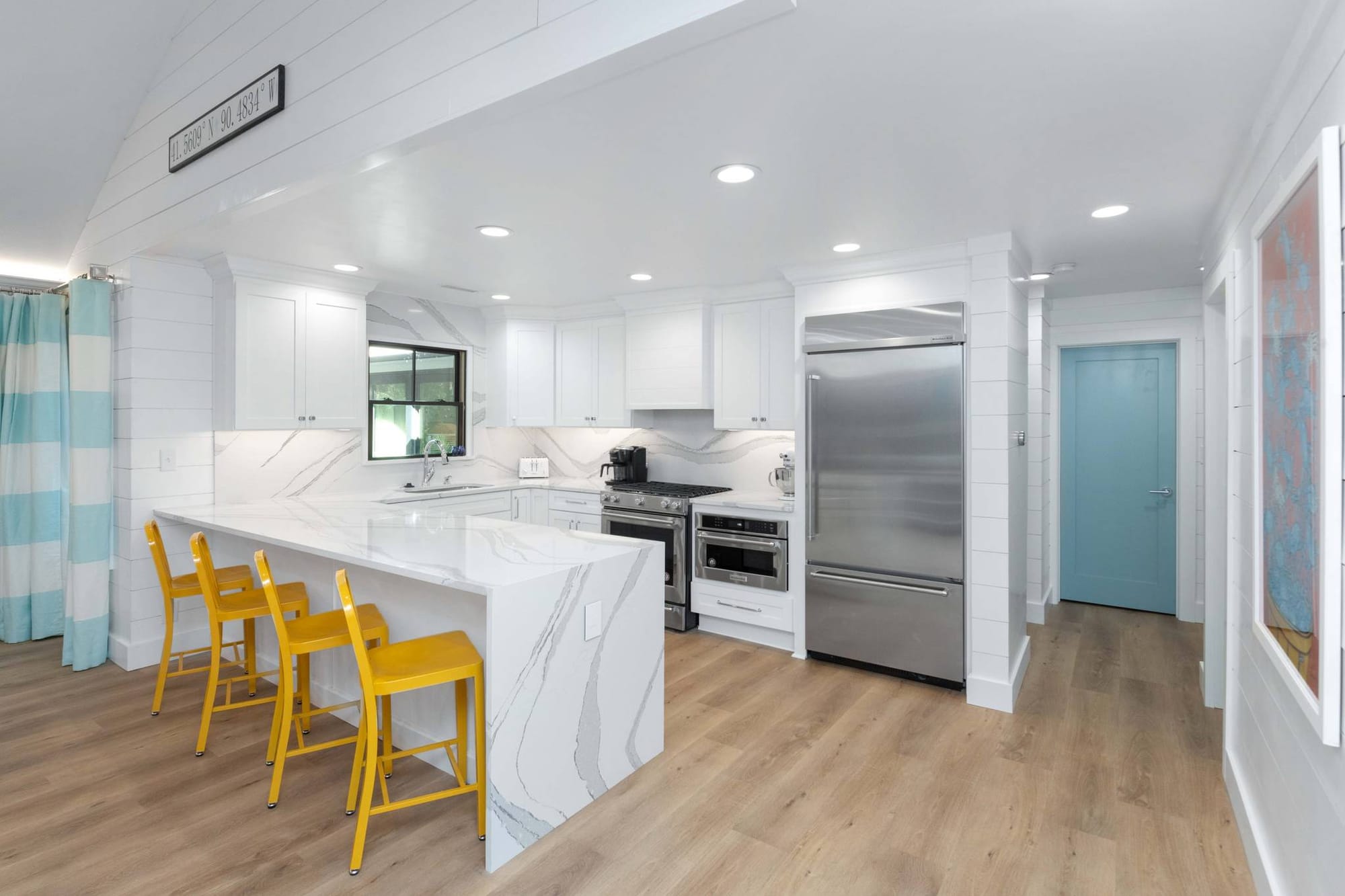 Modern kitchen with yellow chairs.