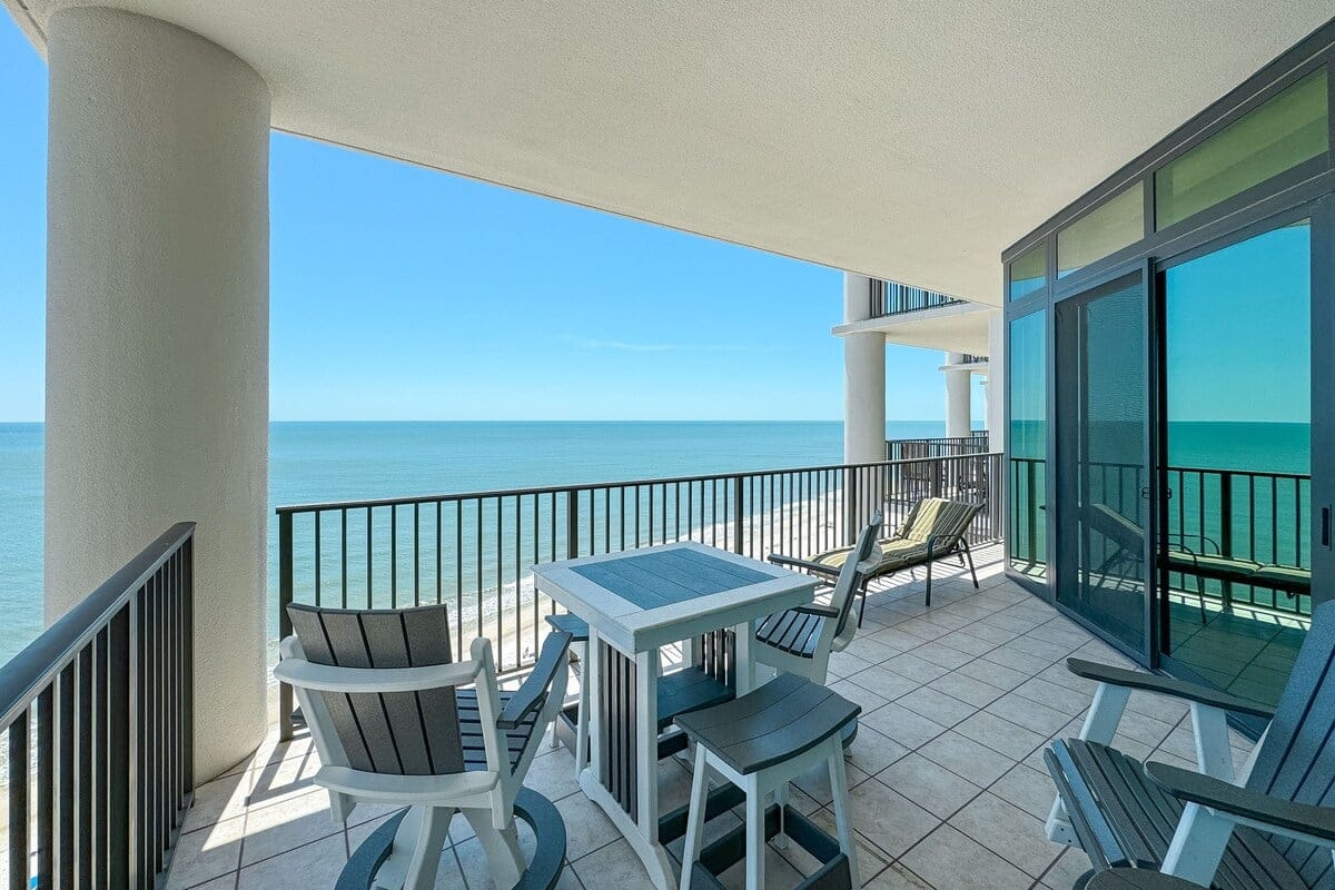 Oceanview balcony with chairs, table.