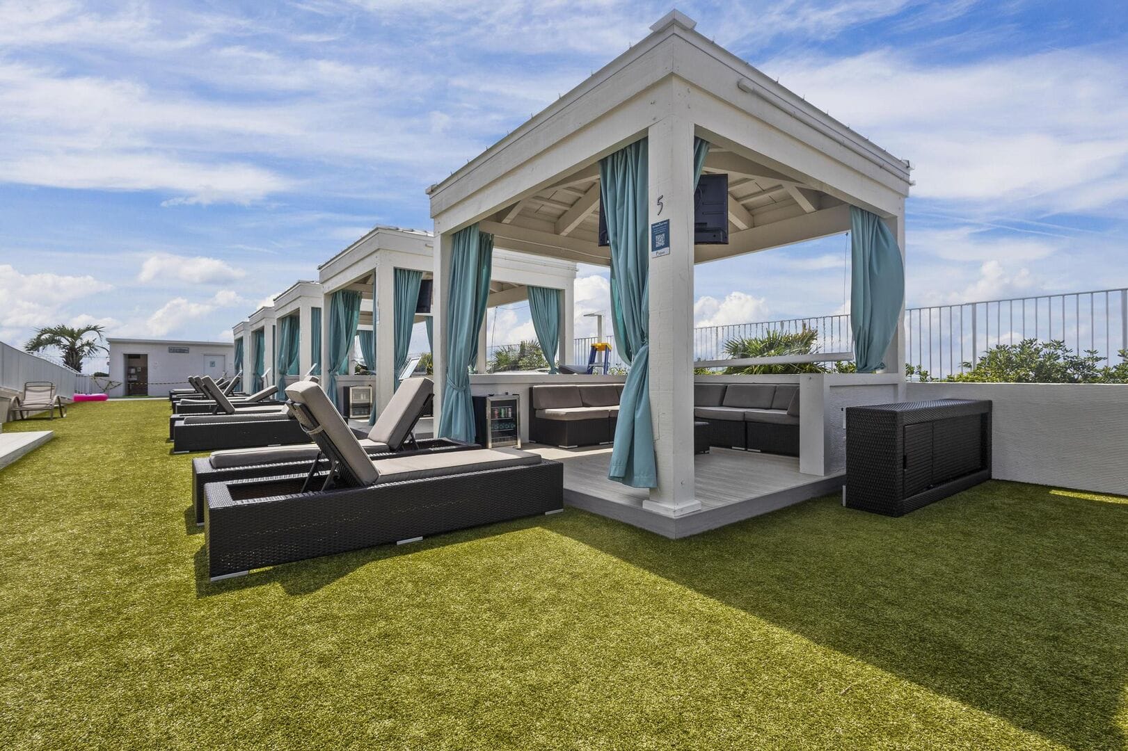 Rooftop cabanas with lounge chairs.