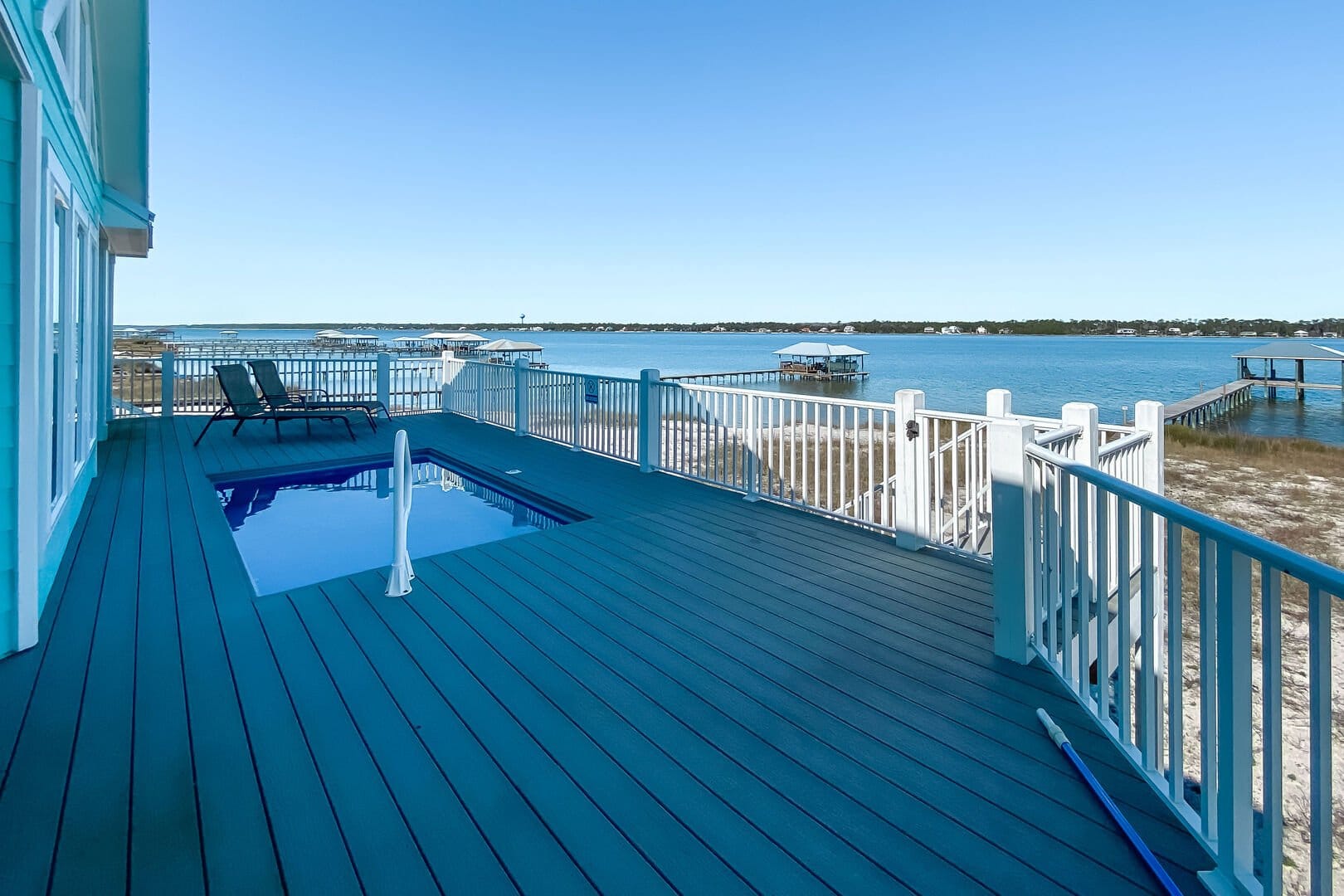 Deck with pool and waterfront.