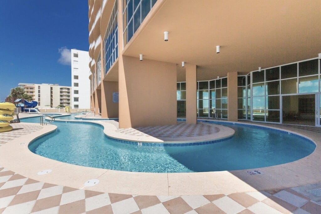 Outdoor curved swimming pool near building.