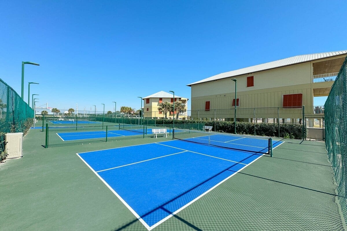 Blue pickleball courts, sunny day.