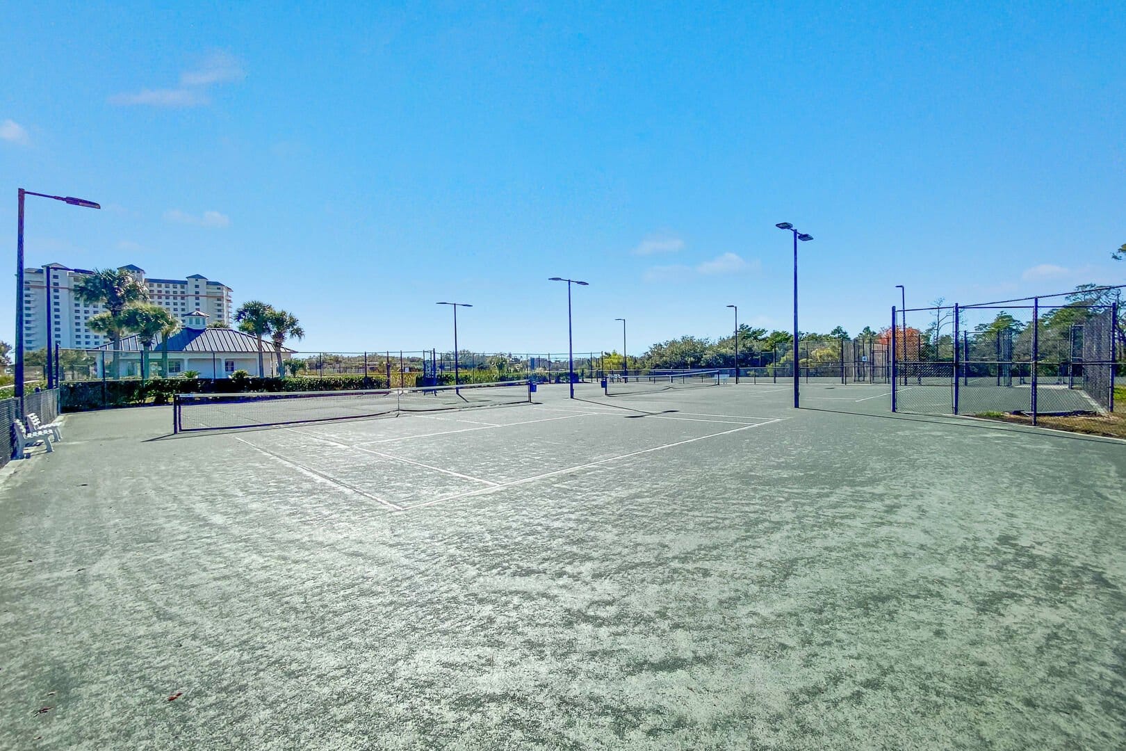 Empty tennis courts under blue sky.