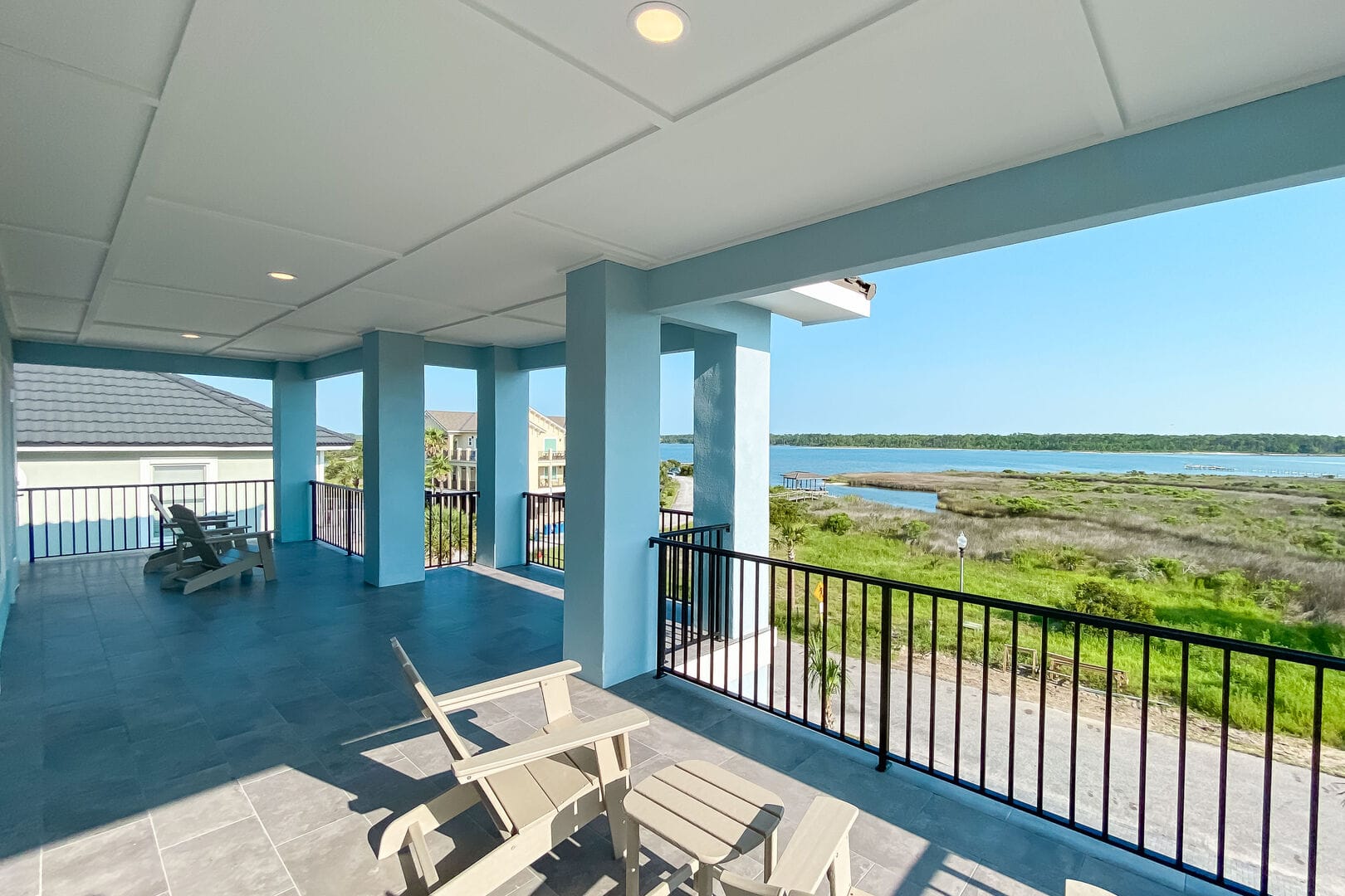 Covered porch overlooking grassy landscape.