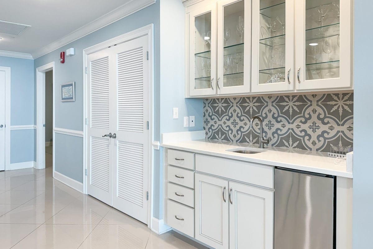 Modern kitchenette with patterned backsplash.