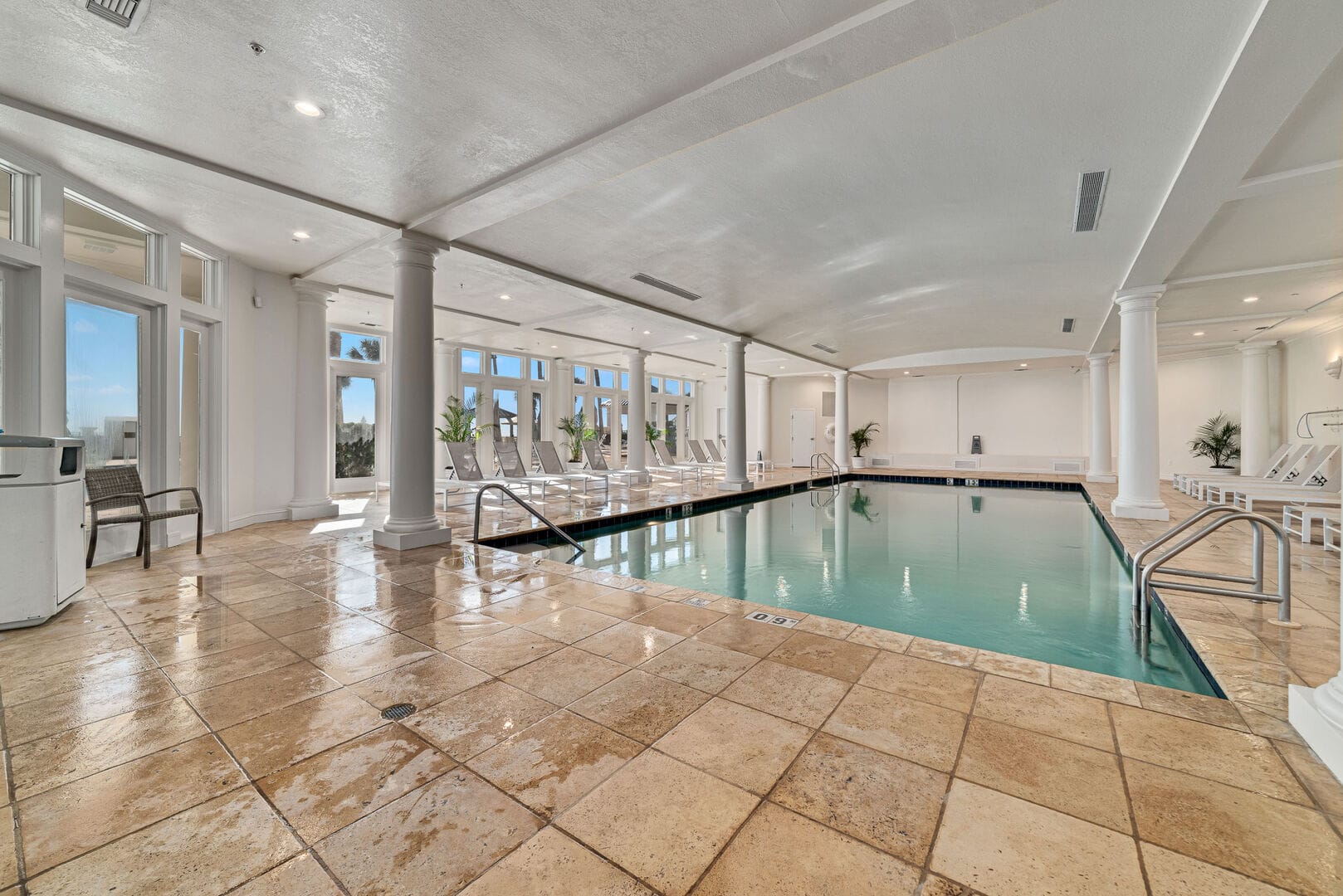 Indoor swimming pool with lounge chairs.