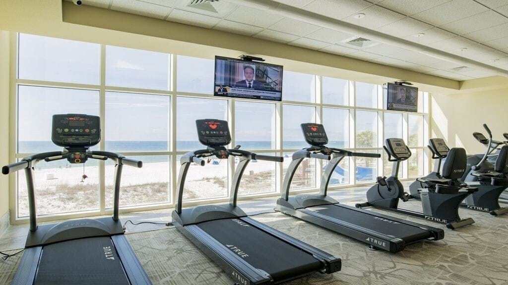 Gym with treadmills overlooking ocean.