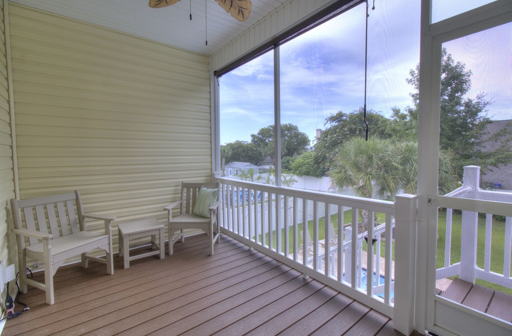 Enclosed porch with outdoor chairs.