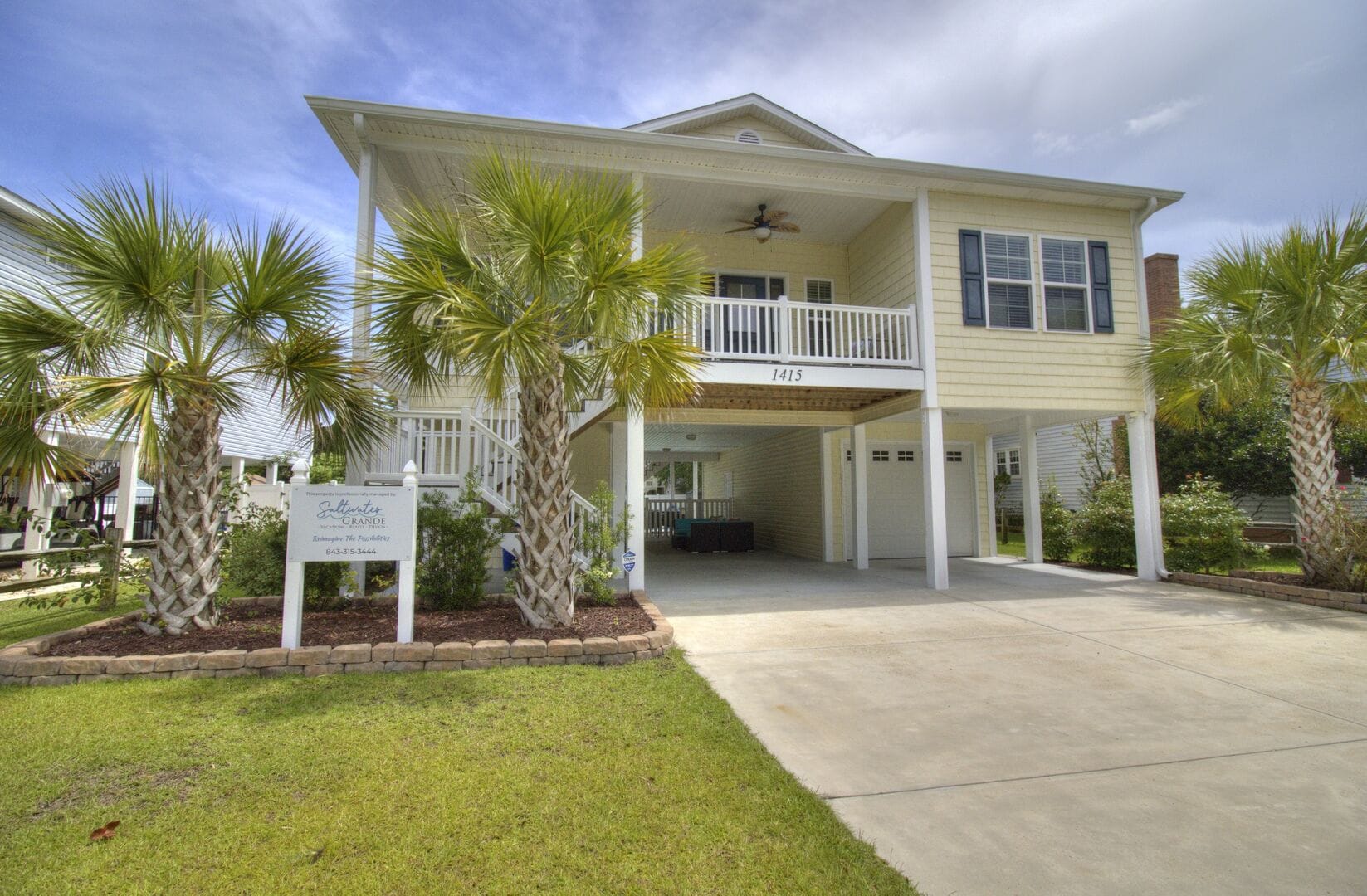 Two-story house with palm trees.