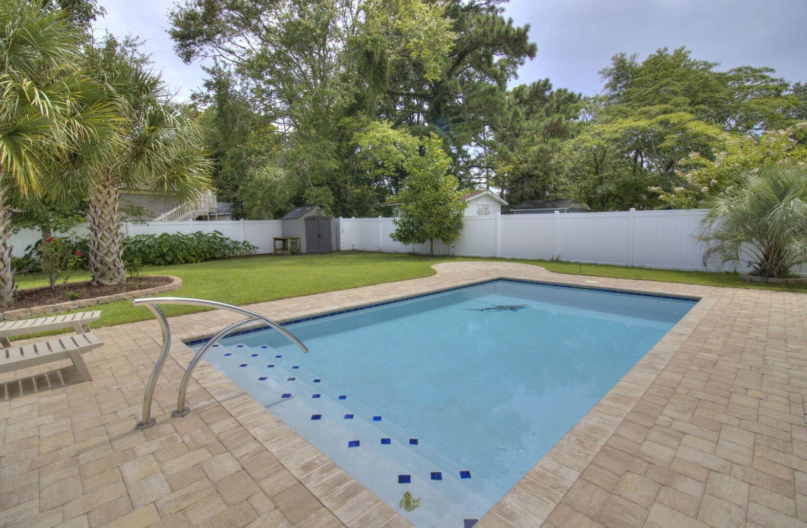 Backyard with pool and trees.