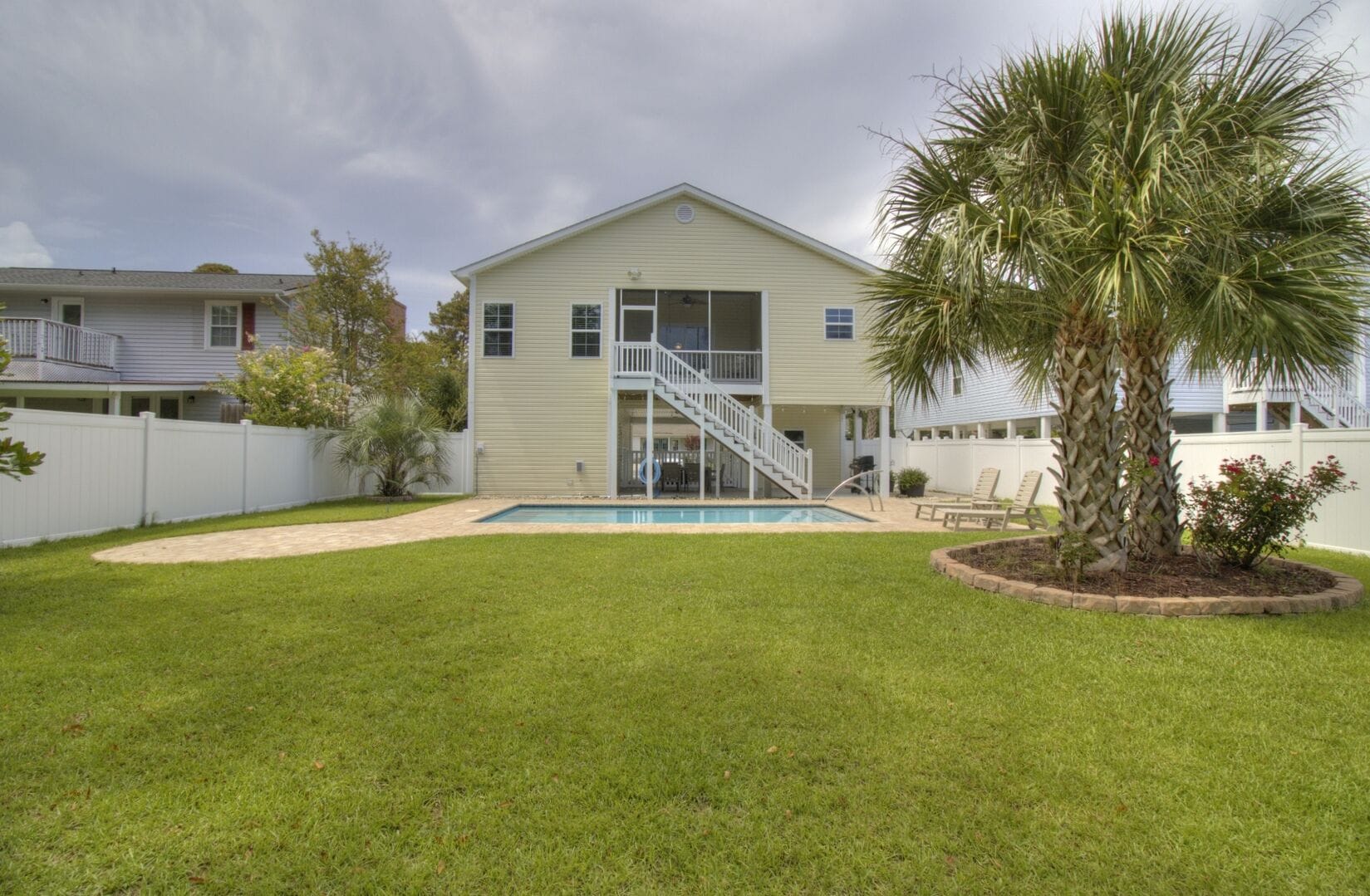 House with pool and palm trees.