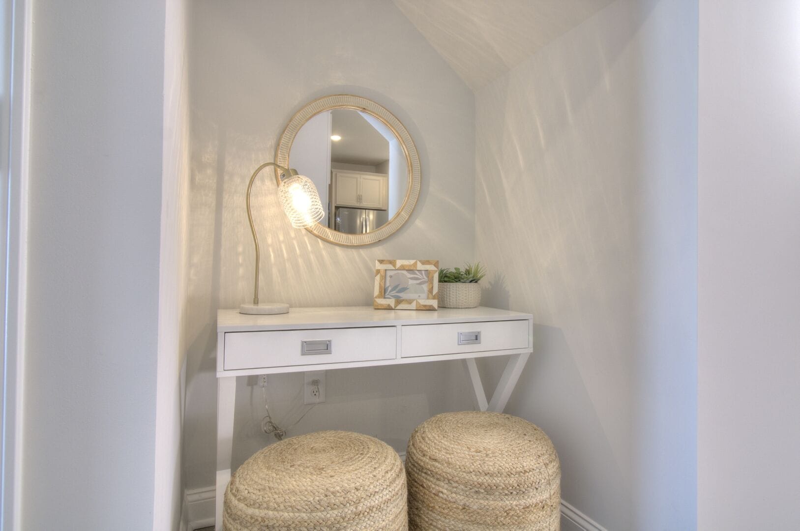 White vanity with mirror and stools.