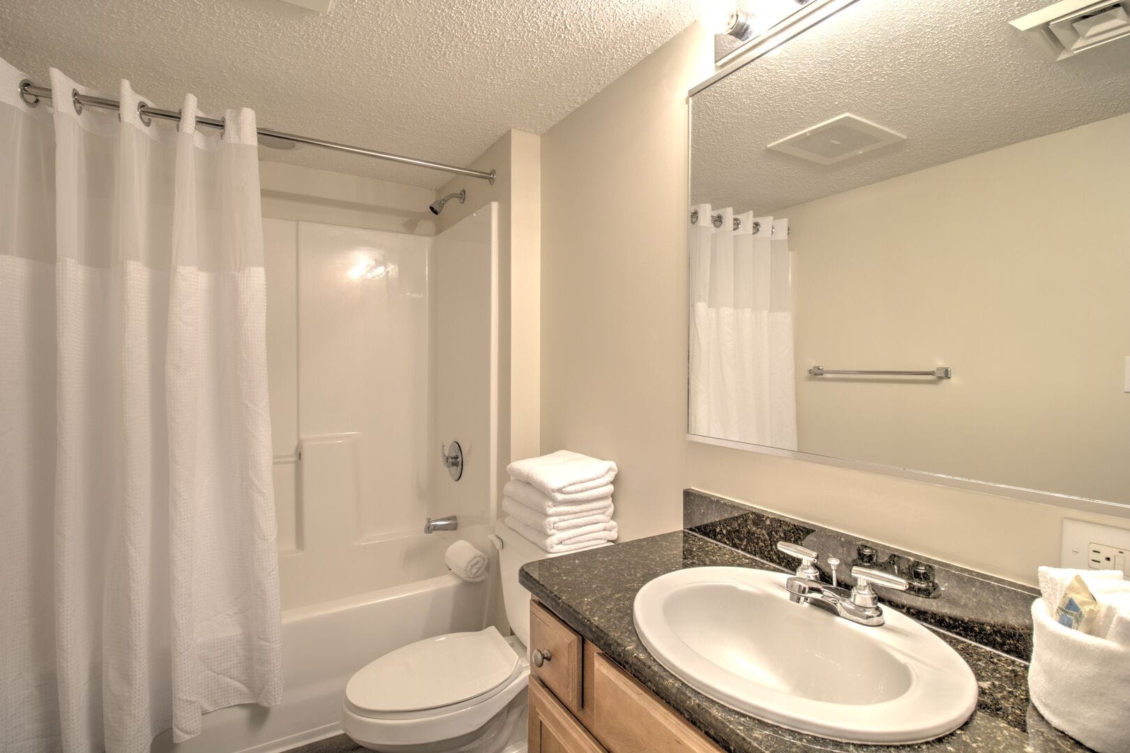 Clean bathroom with towels and mirror.