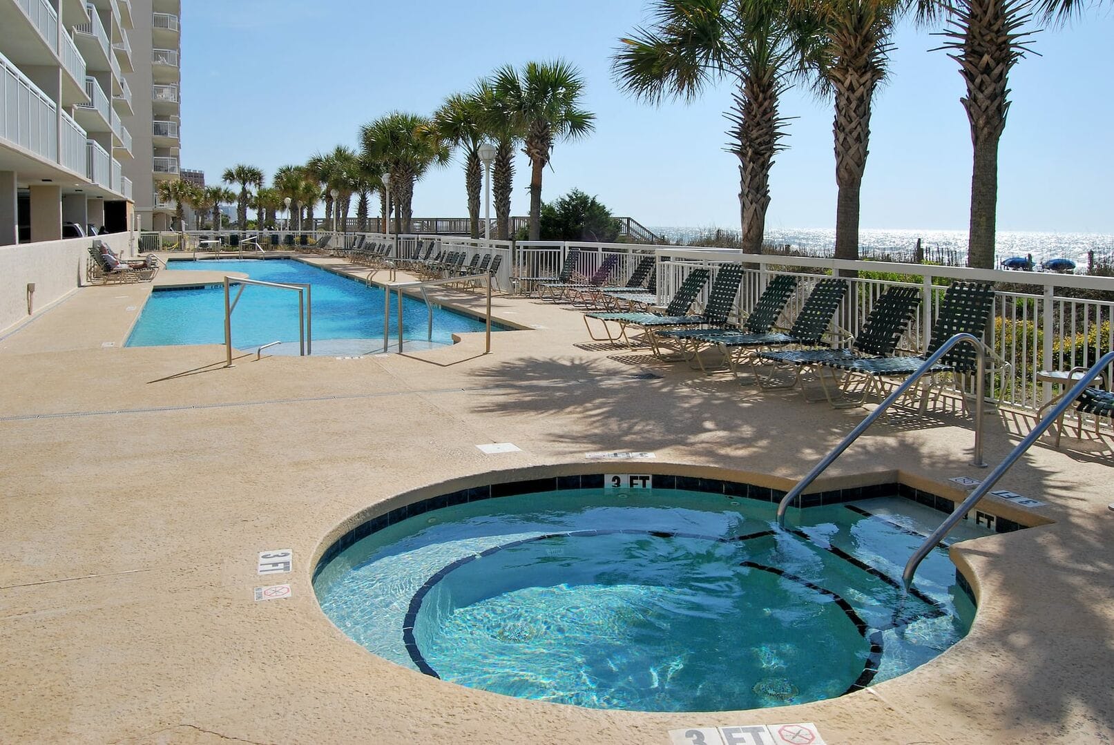 Pool and hot tub by ocean.