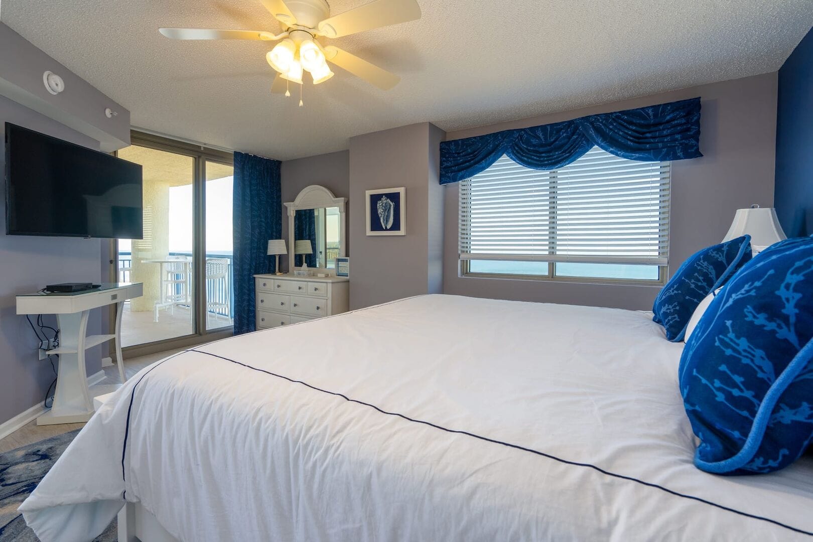 Bedroom with bed, TV, balcony.