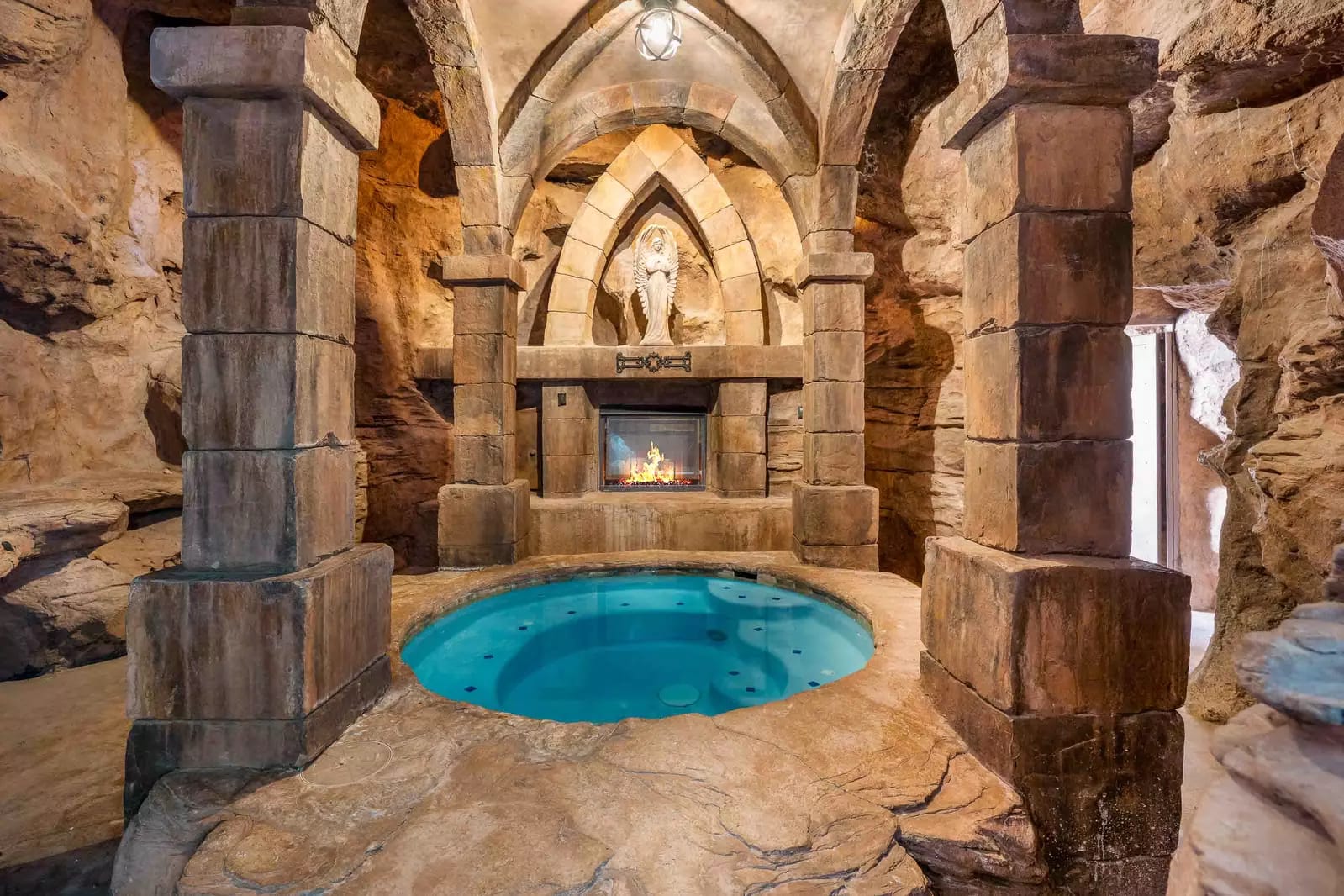 Grotto-style indoor pool with fireplace.