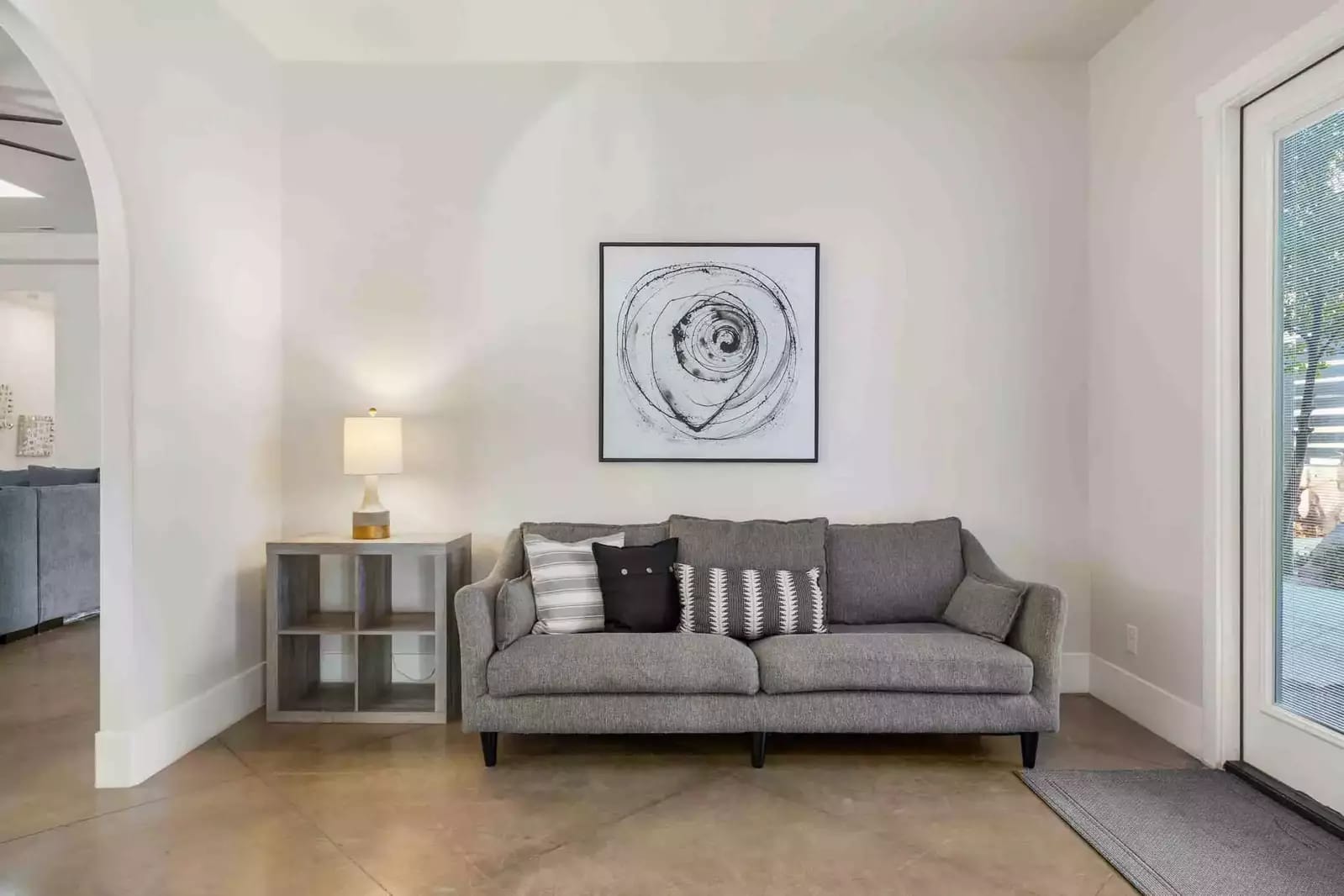 Gray sofa, abstract artwork, side table.