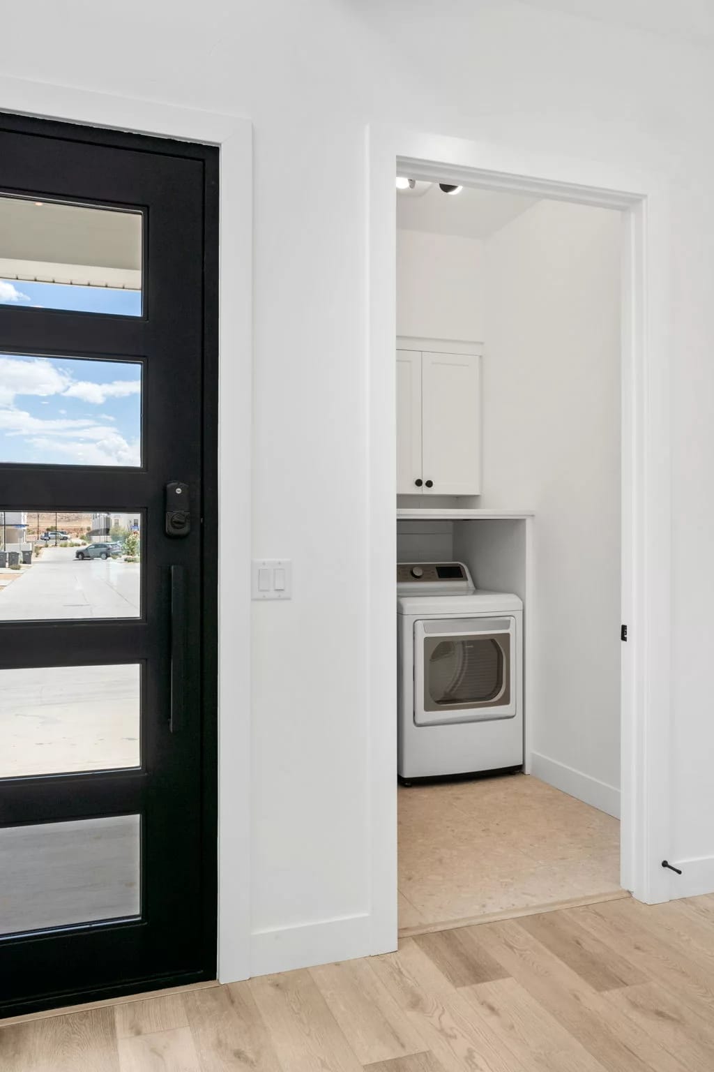 Laundry room near black door.