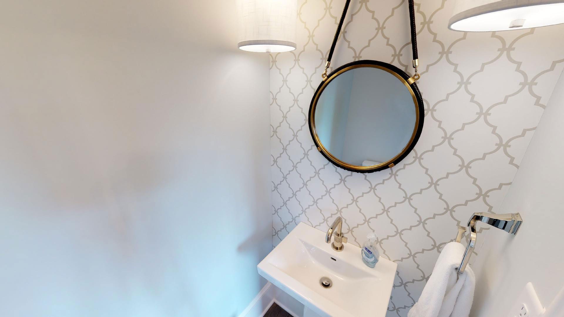 Small bathroom with round mirror.