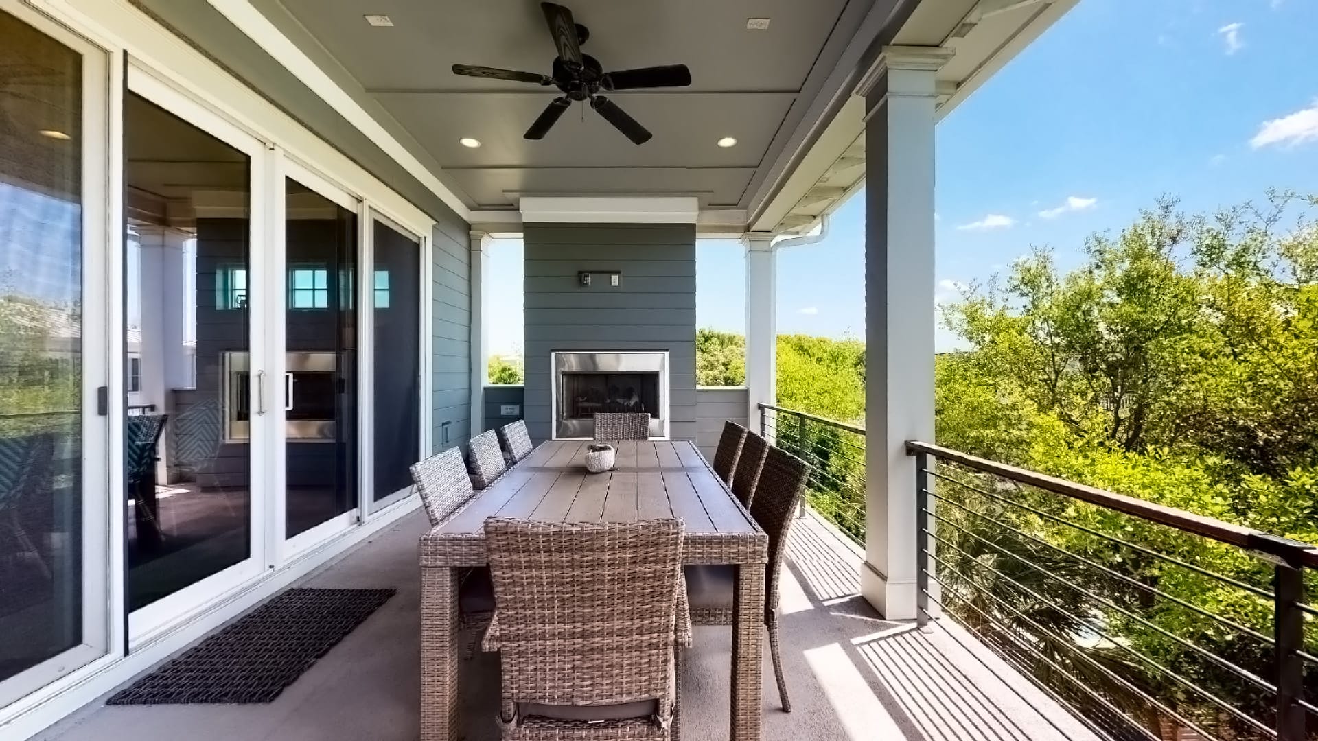 Covered patio with table and fireplace.