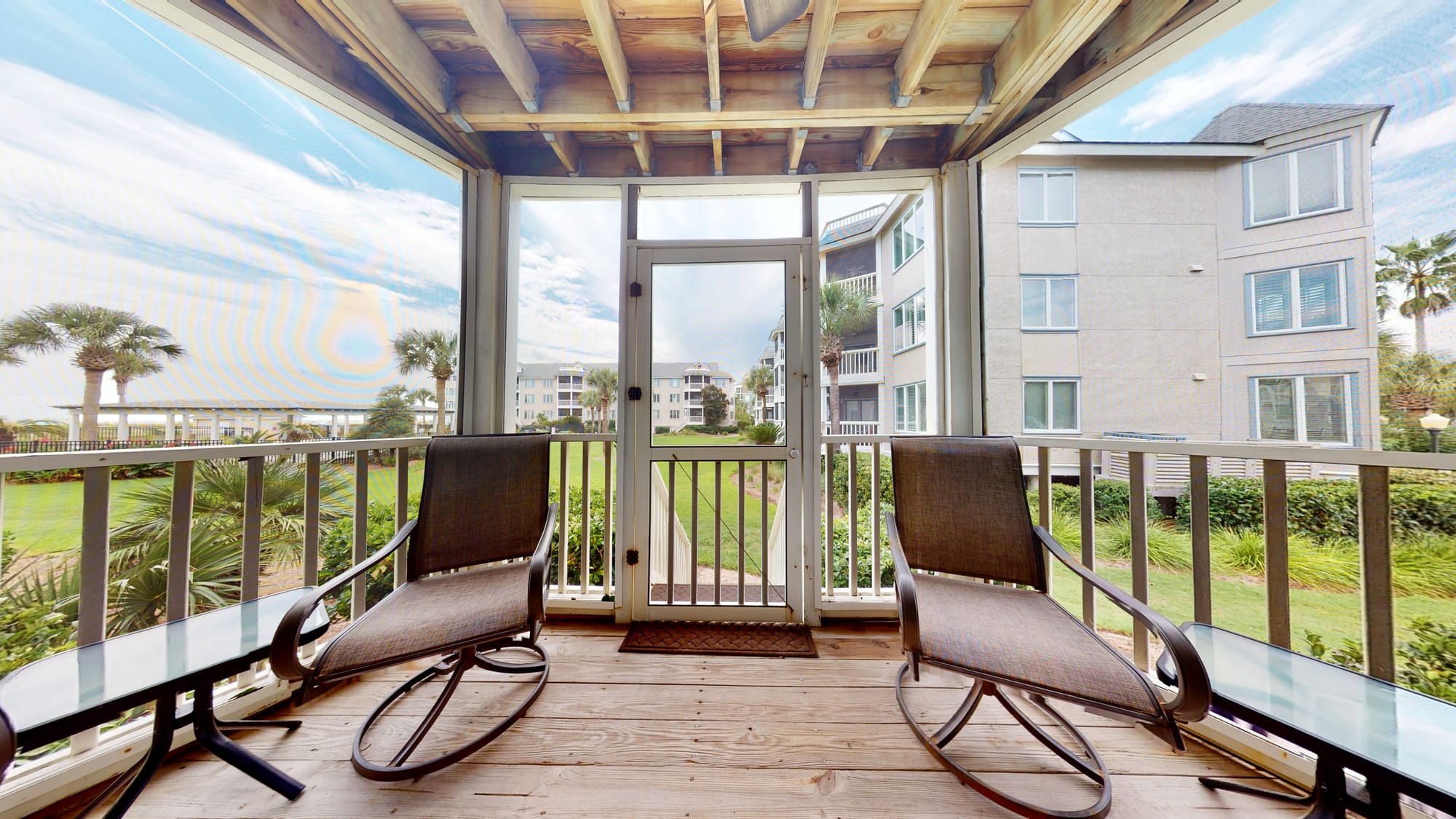 Balcony with chairs, garden view.