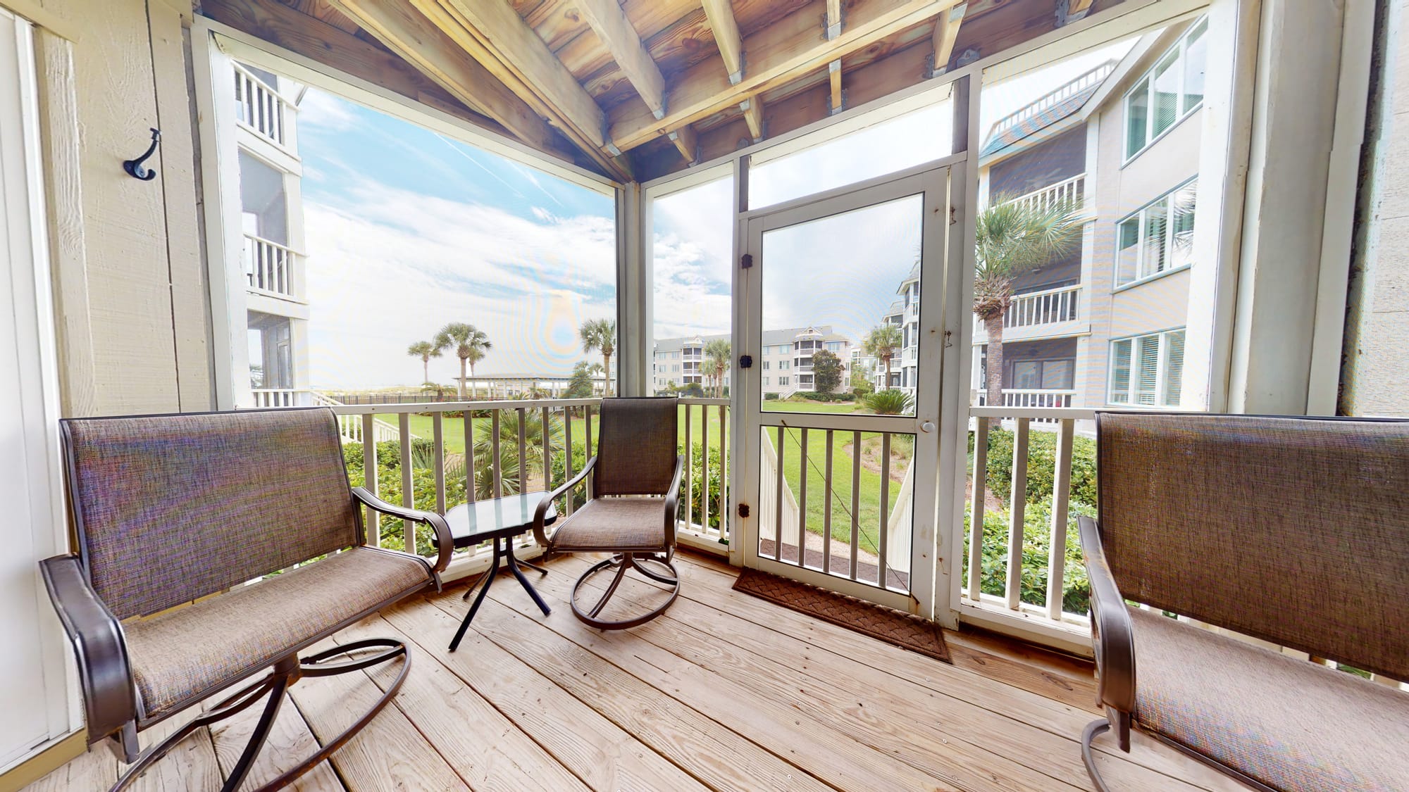 Screened porch with outdoor furniture.