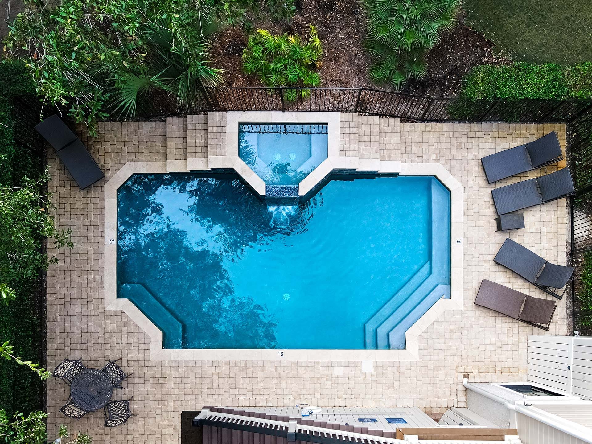 Backyard pool with lounge chairs.