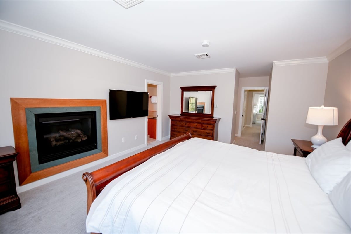 Modern bedroom with fireplace and TV.