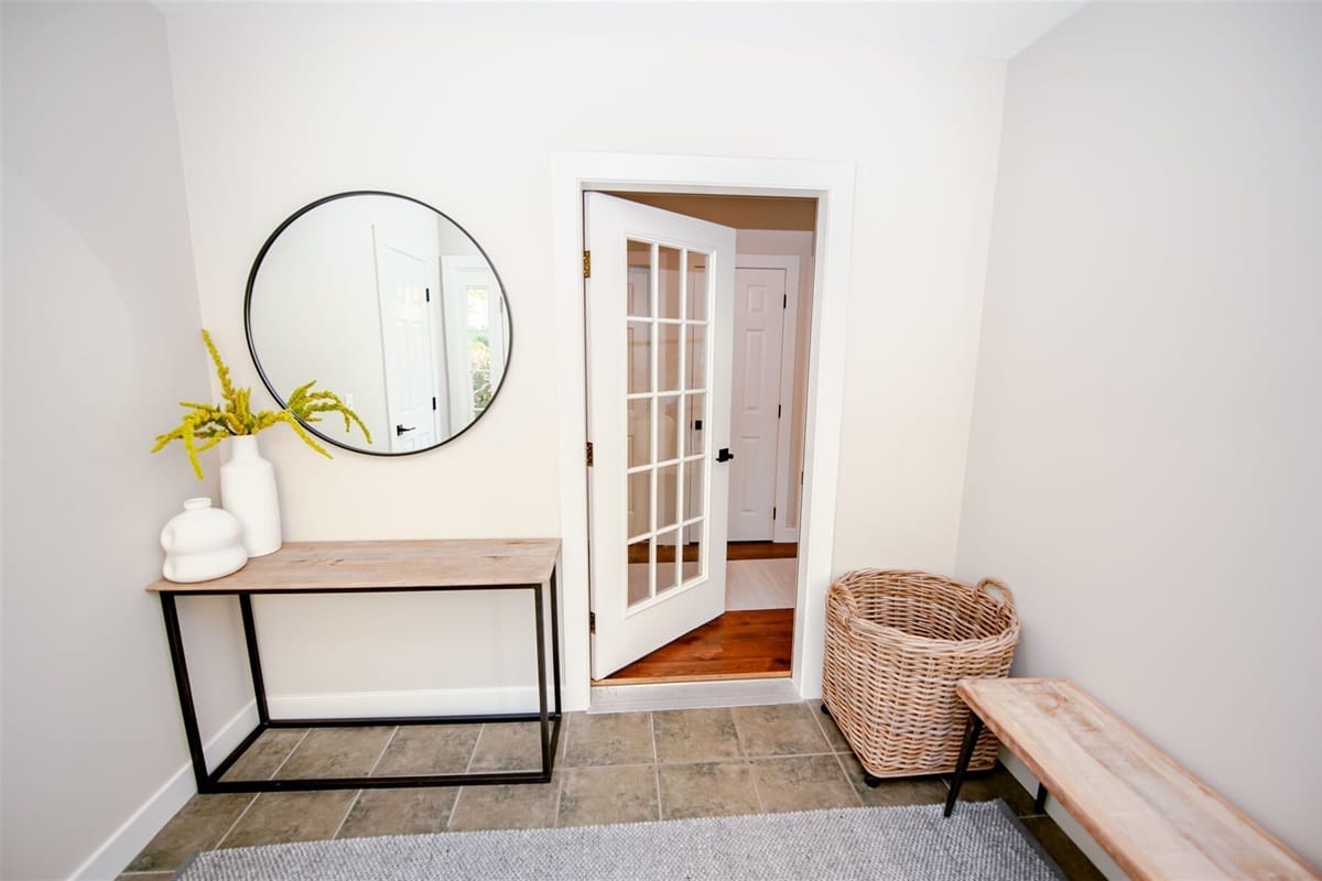 Minimalist entryway with round mirror.