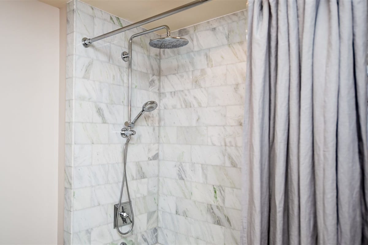 Marble shower with curtain closed.