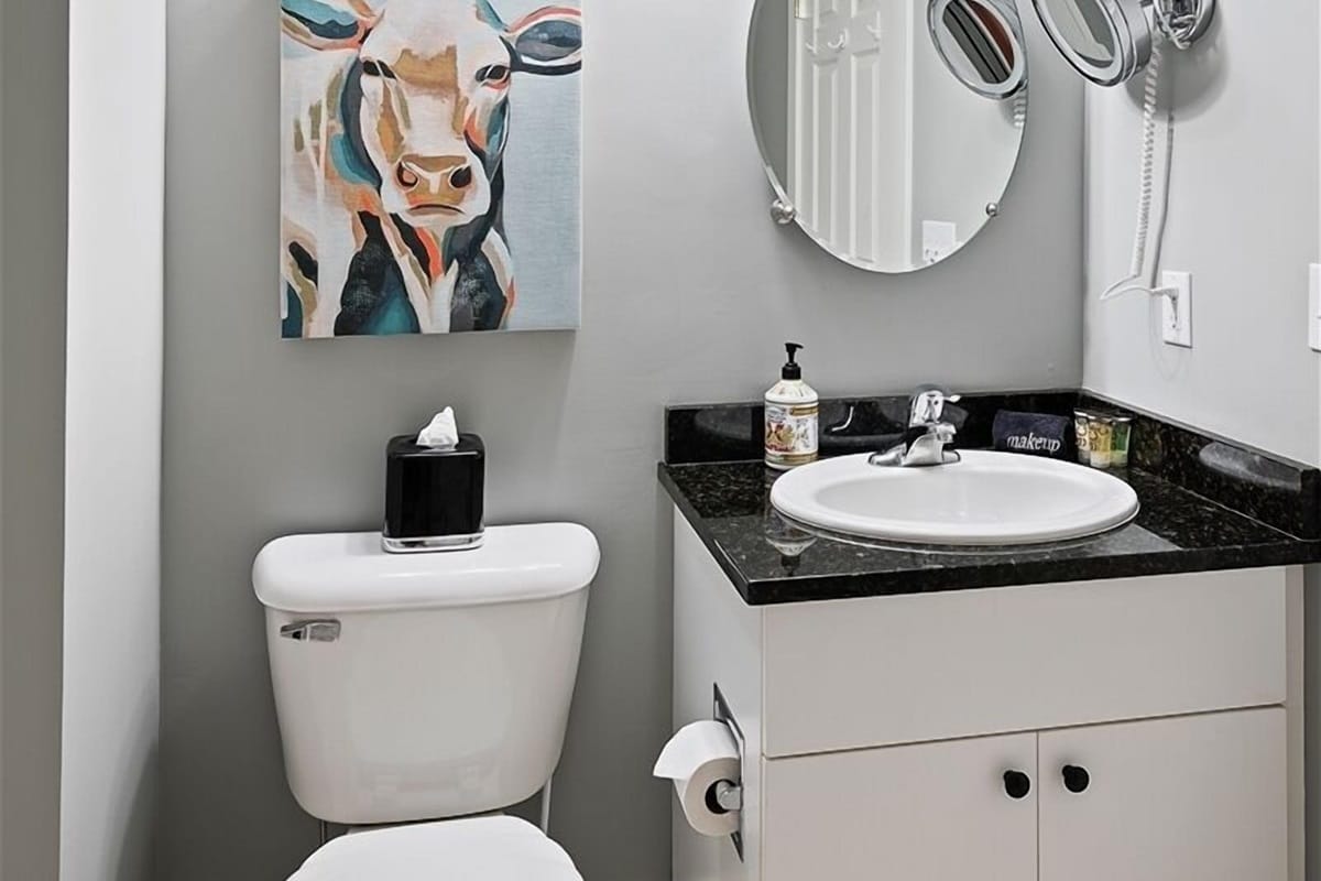 Bathroom with cow painting decor.