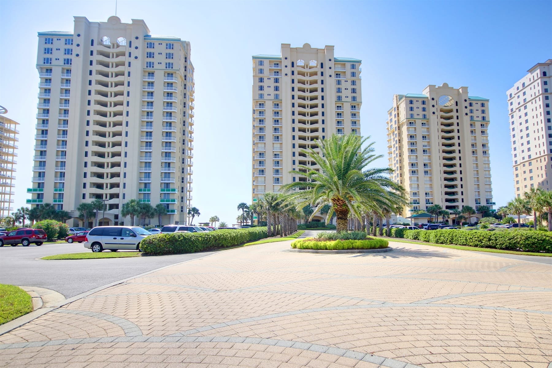 Three tall buildings, palm tree foreground.