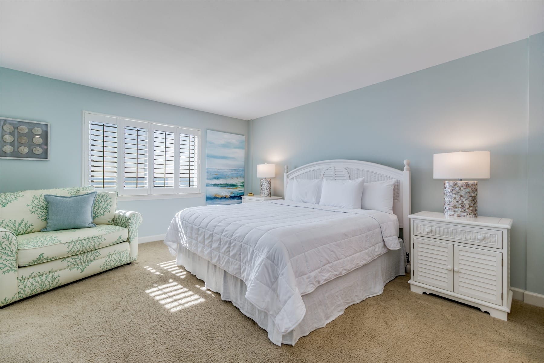 Coastal-themed bedroom with white bed.