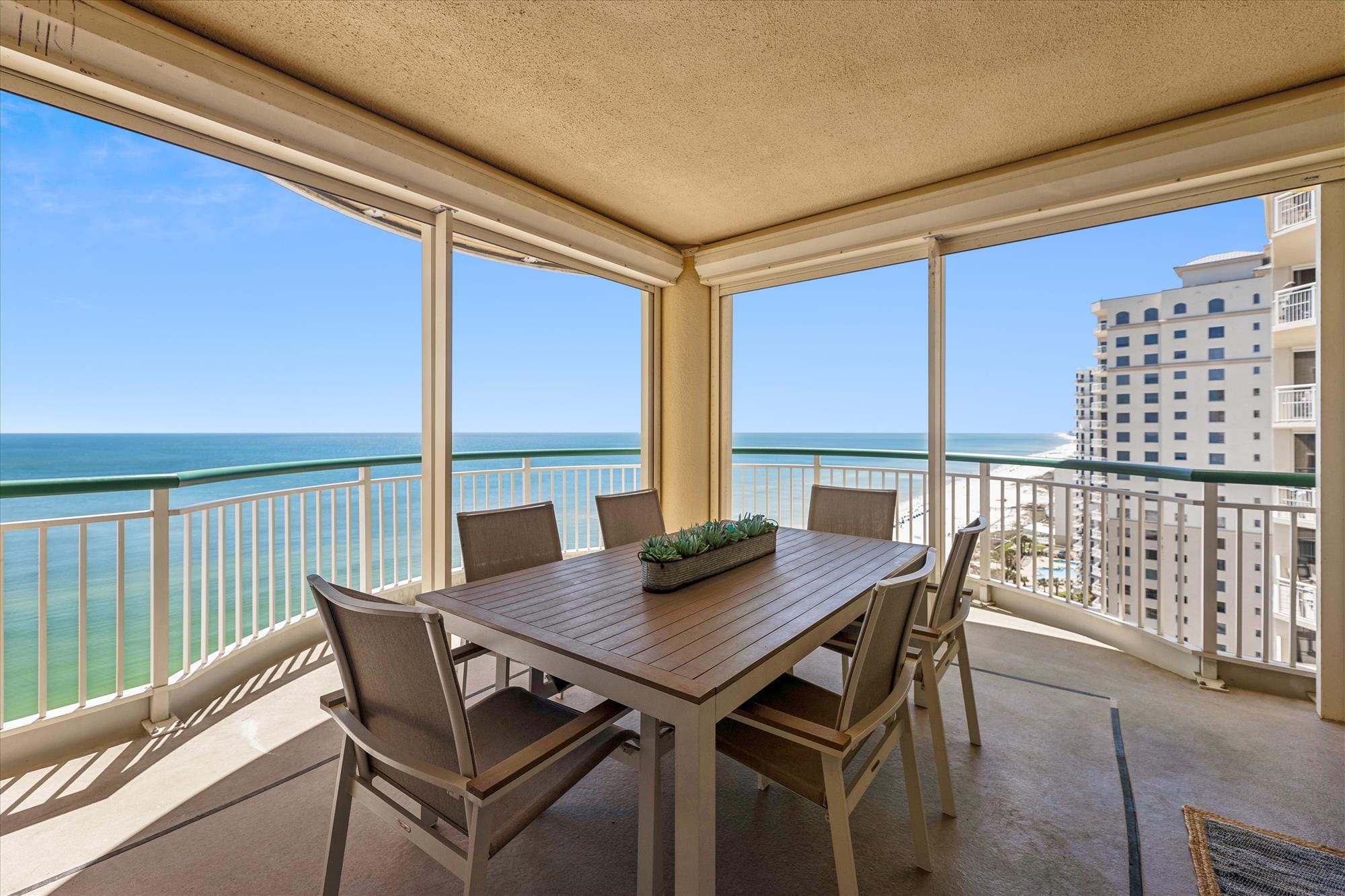 Outdoor dining overlooking ocean and buildings.