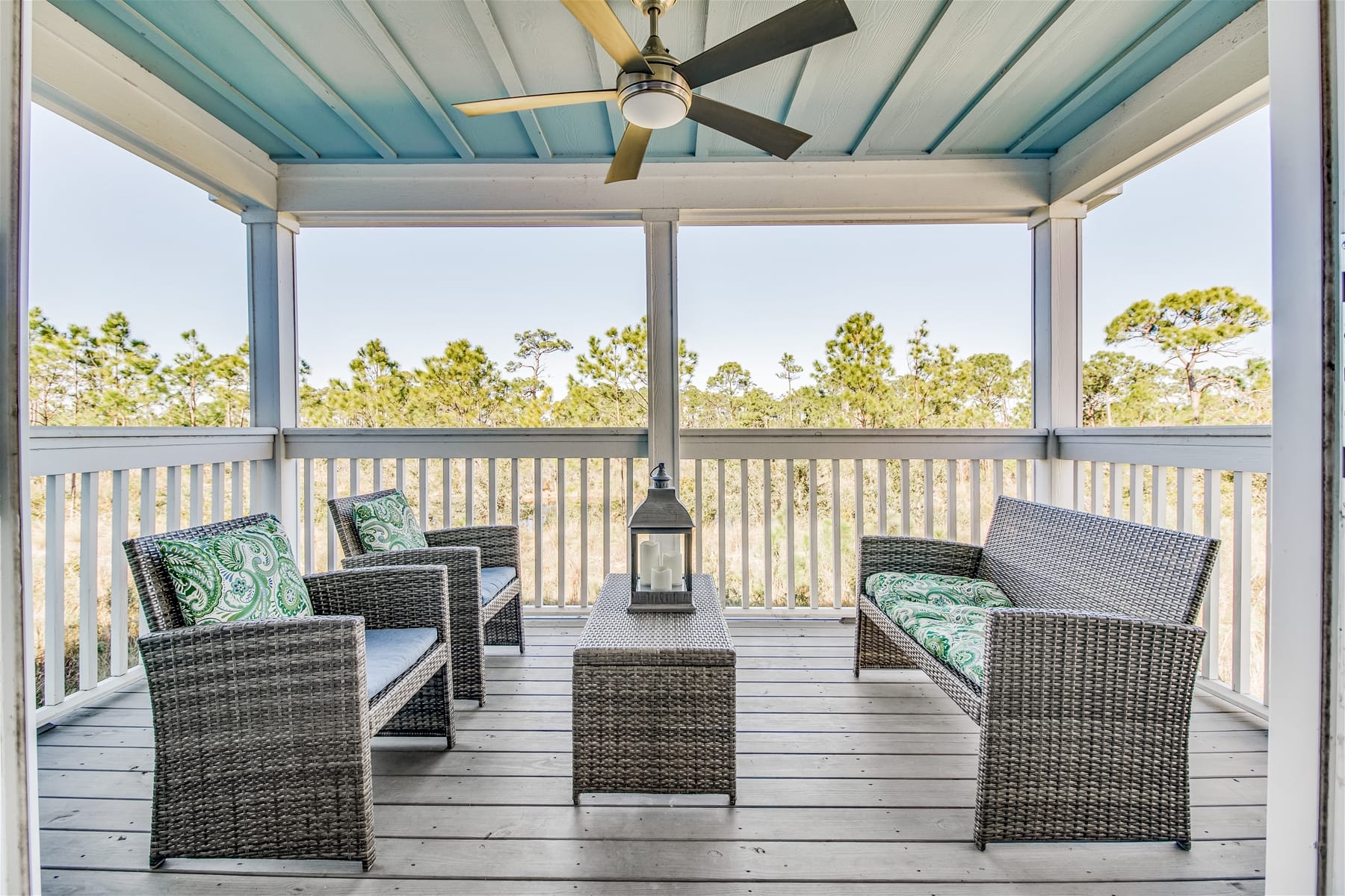 Covered porch with wicker furniture.