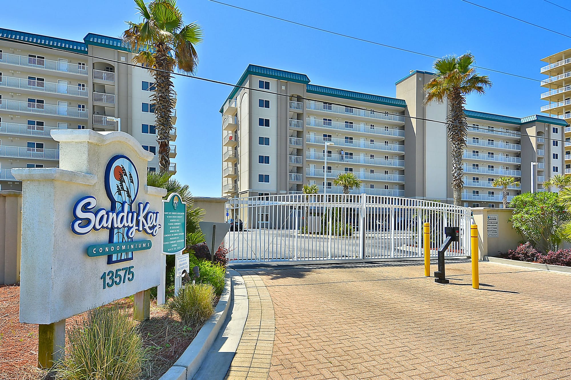 Condominium entrance with palm trees.