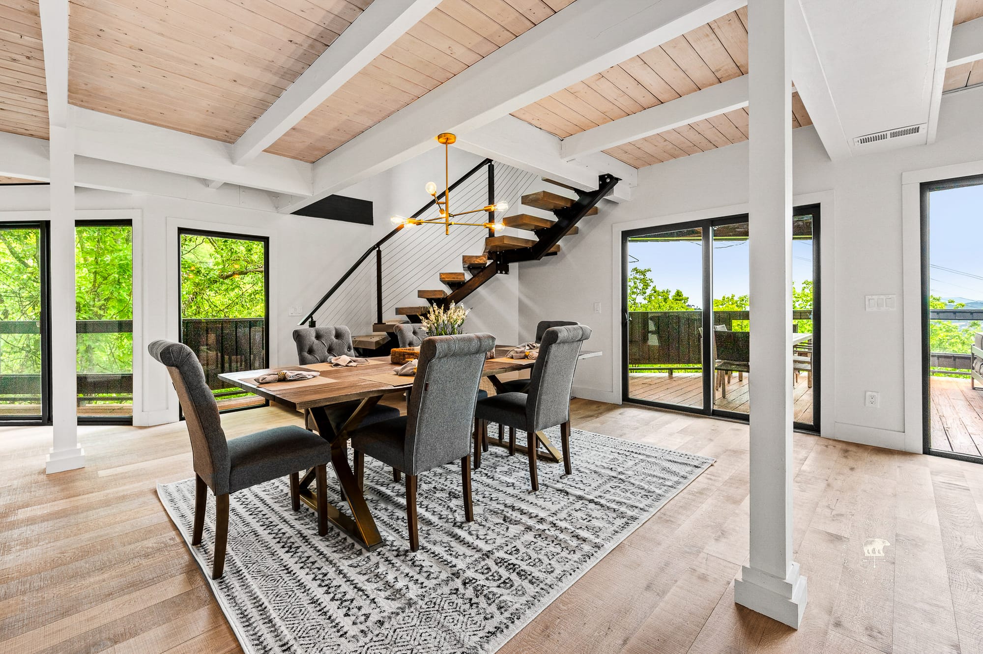 Modern dining area with staircase.