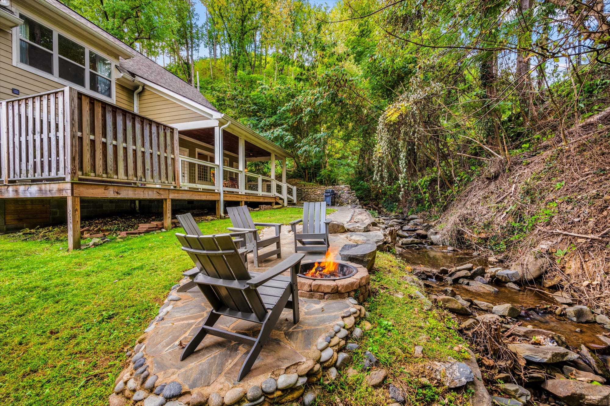 Patio chairs by fire pit, stream.