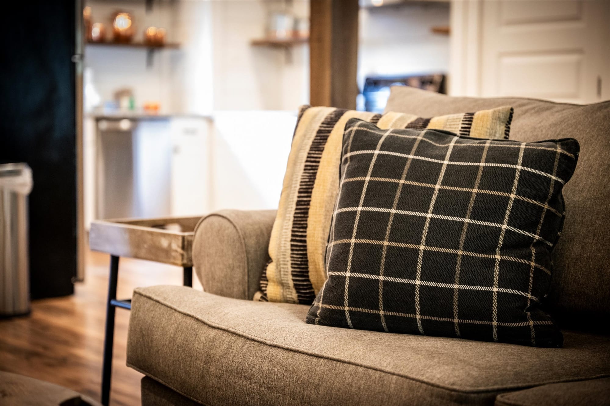 Sofa with checkered and striped pillows.