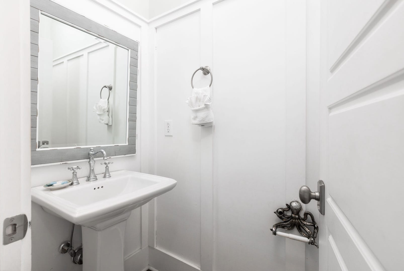 White bathroom with octopus towel holder.