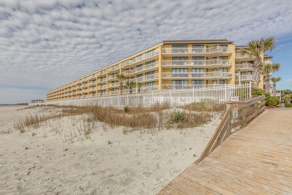 Beachfront hotel under cloudy sky.