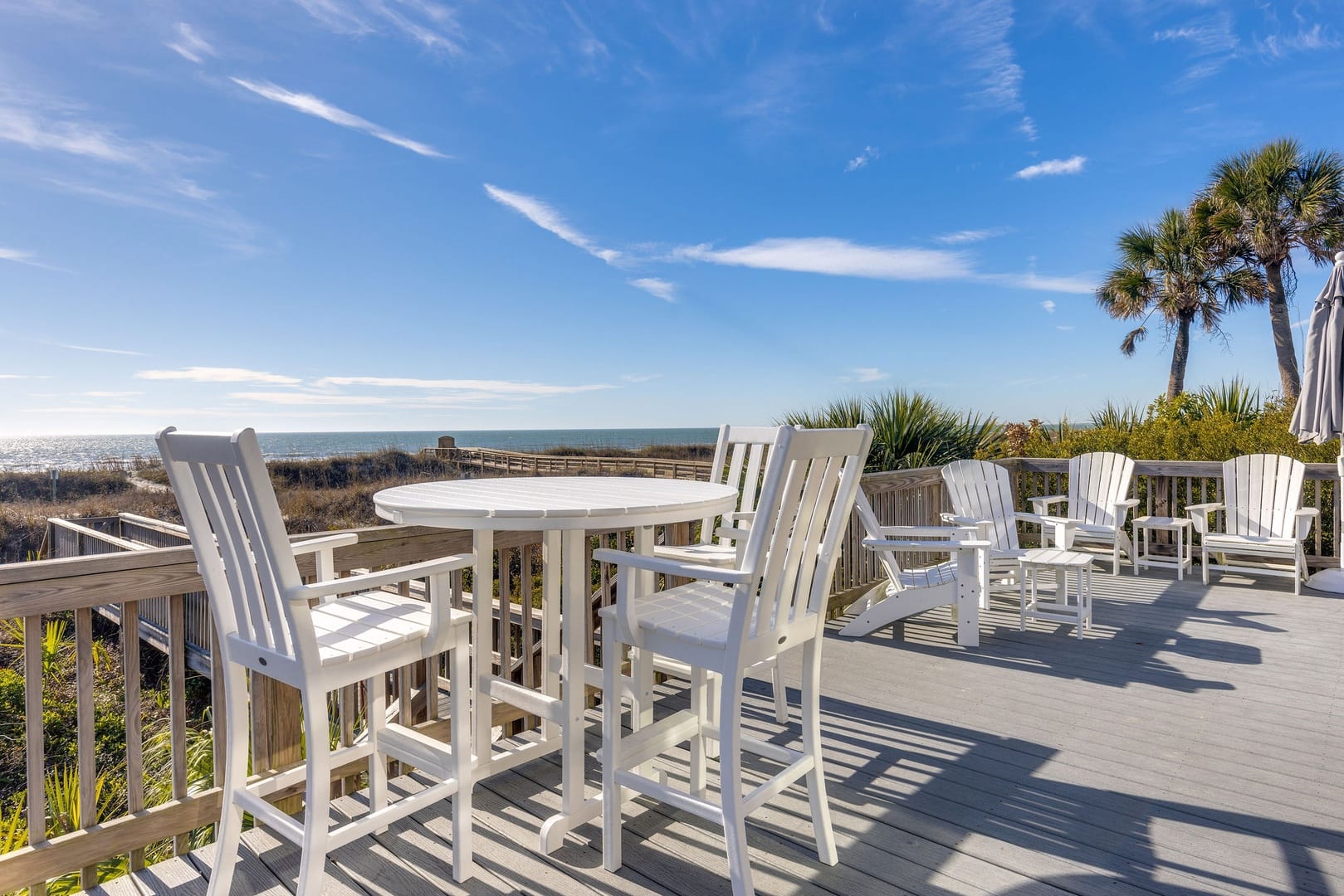 Deck with white outdoor furniture.